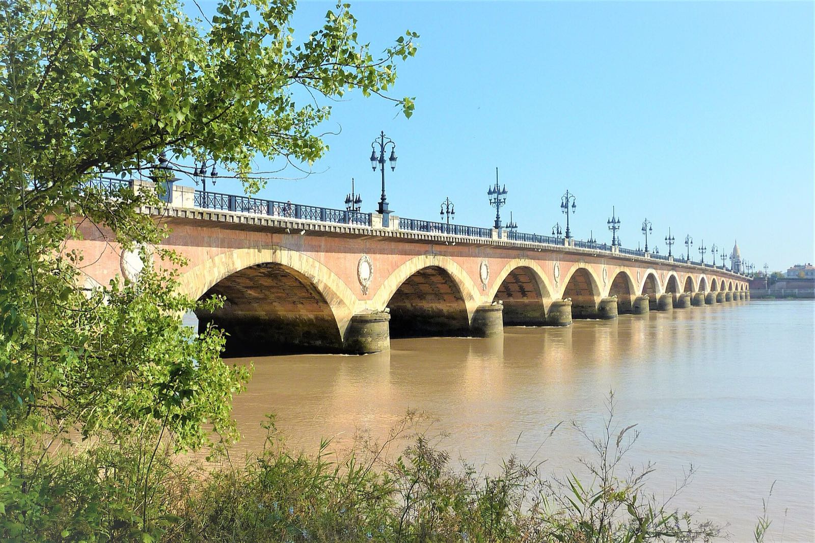 Le pont de pierre enjambant la Garonne à Bordeaux, vu depuis la rive.